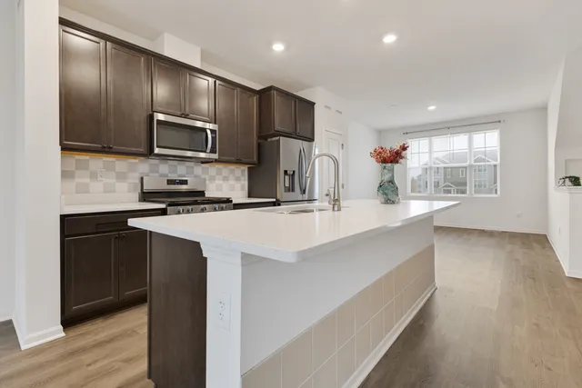 a kitchen with granite countertop a sink a counter space appliances and cabinets