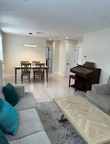 a living room with furniture a dining table and a piano table