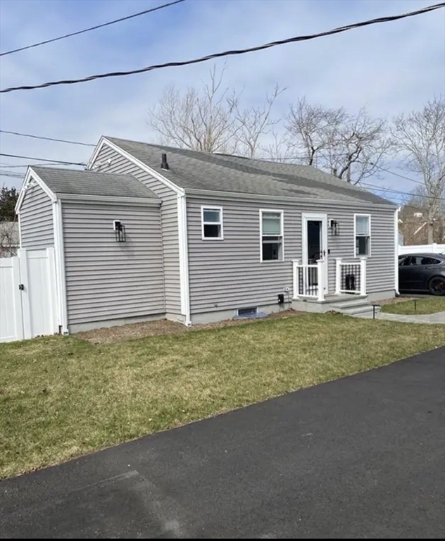 65 Louis Street, Unit A Barnstable, MA 02601 - Photo 2 of 15 a front view of a house with a yard and garage