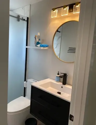 a bathroom with a sink a toilet and a mirror