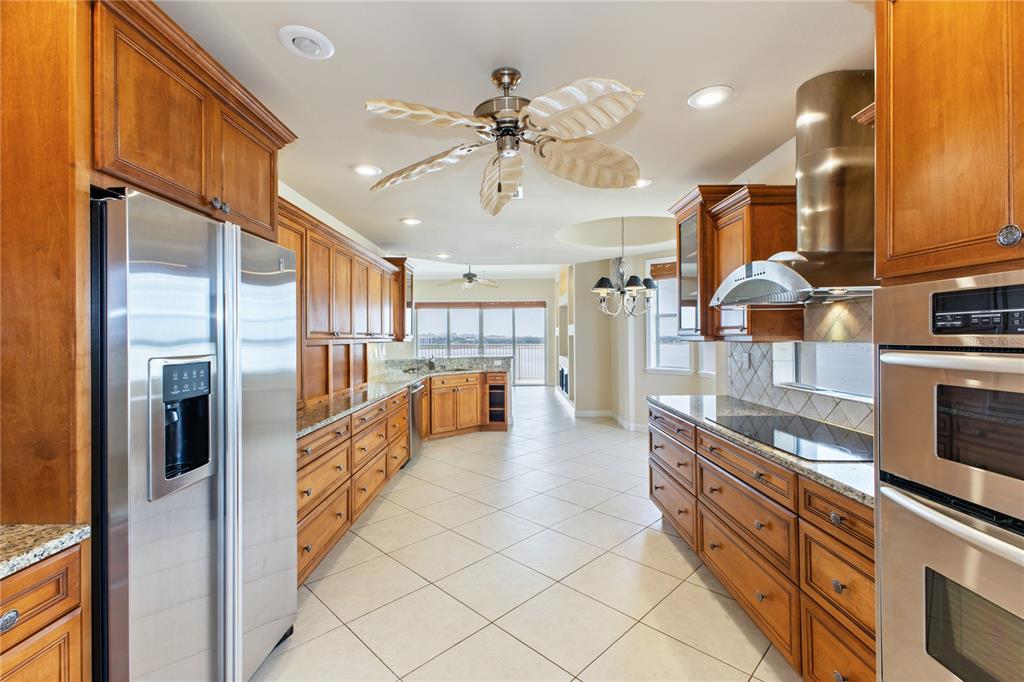 8755 The Esplanade, Unit 126 Orlando, FL 32836 - Photo 15 of 30 a kitchen with stainless steel appliances kitchen island granite countertop a refrigerator and a sink