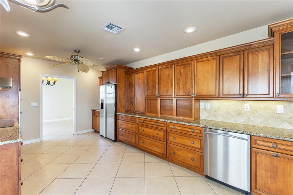 8755 The Esplanade, Unit 126 Orlando, FL 32836 - Photo 17 of 30 a kitchen with stainless steel appliances granite countertop a refrigerator and a sink