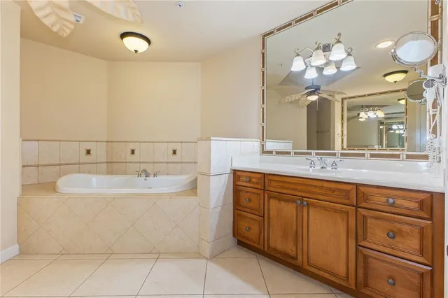 a spacious bathroom with a double vanity sink mirror and bathtub