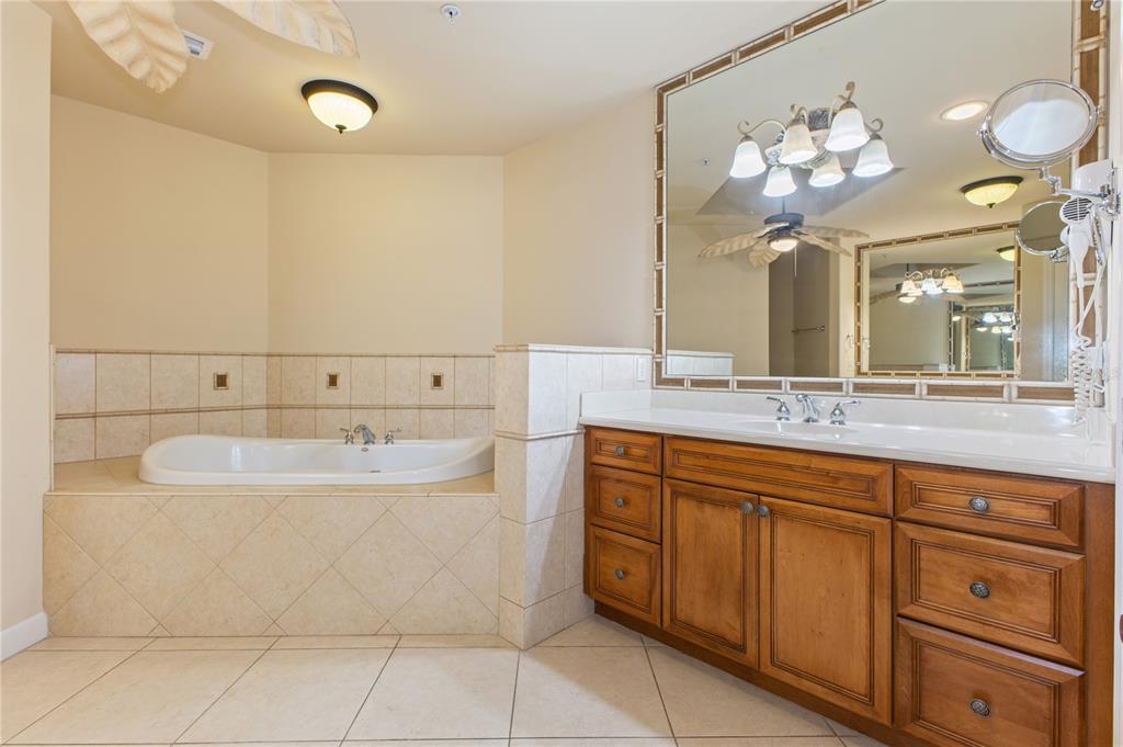 8755 The Esplanade, Unit 126 Orlando, FL 32836 - Photo 26 of 30 a bathroom with a sink a large mirror and a bathtub