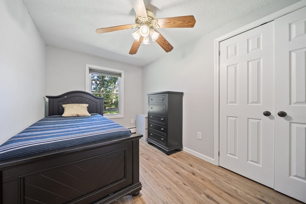 21 Woodman Road Amesbury, MA 01913 - Photo 15 of 30 a bedroom with a bed and a chandelier