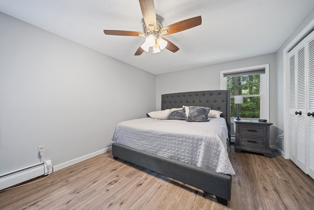 21 Woodman Road Amesbury, MA 01913 - Photo 9 of 30 a bedroom with a bed and wooden floor
