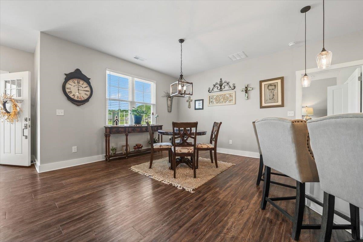 415 Abbey Road, Unit D Munford, TN 38058 - Photo 11 of 35 Open-concept living area featuring wood-finish flooring, a white paneled entry door with frosted glass, and a large window providing natural light