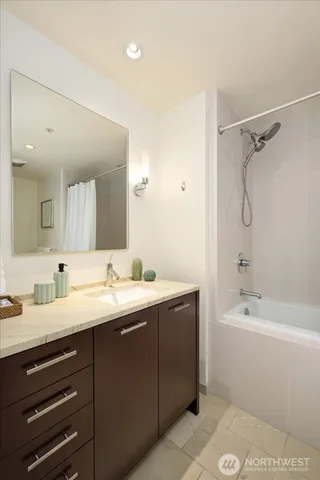 a bathroom with a tub a sink and mirror