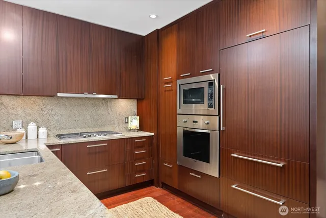 a kitchen with stainless steel appliances granite countertop a refrigerator and a stove
