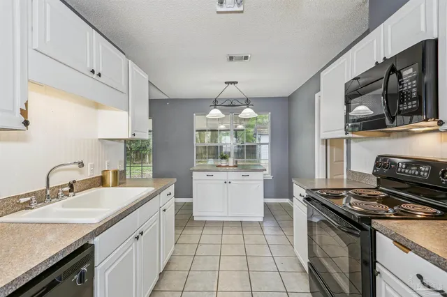 a kitchen with a sink stove top oven and microwave