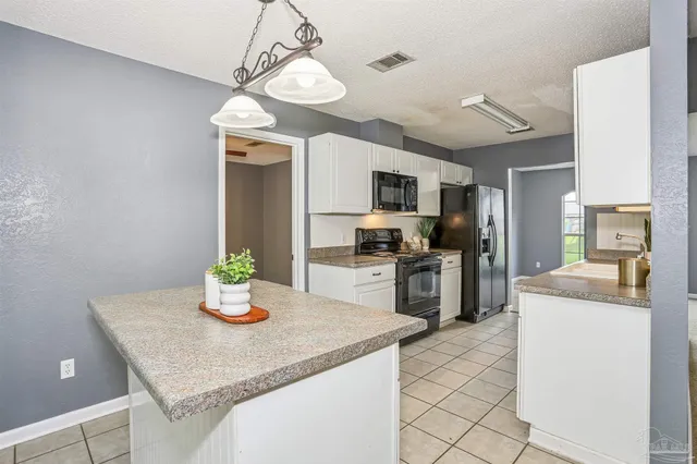 a kitchen with a sink a counter space appliances and cabinets