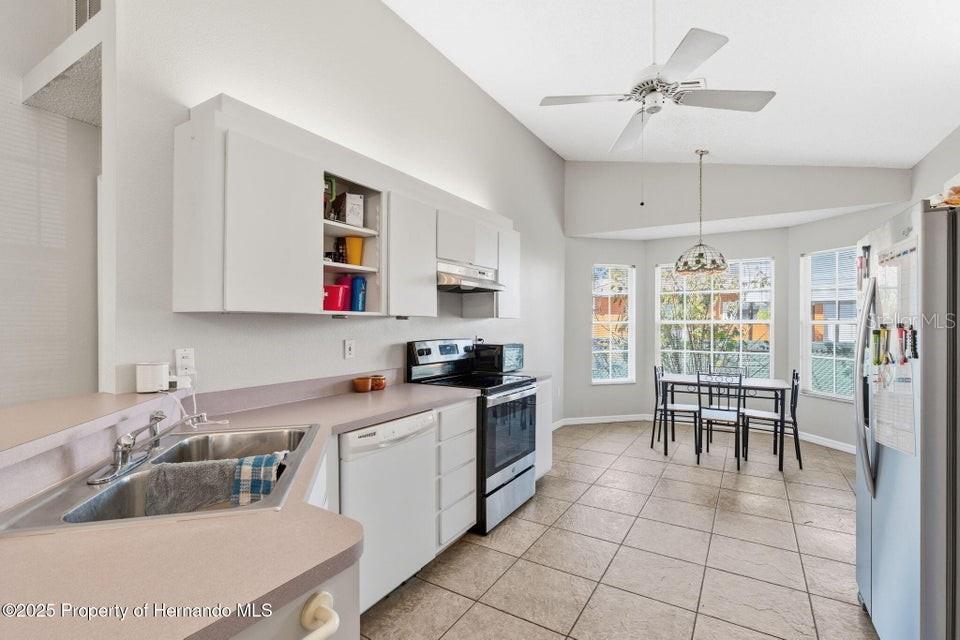 10290 Adler Street Spring Hill, FL 34608 - Photo 12 of 34 a kitchen that has a cabinets counter space and appliances