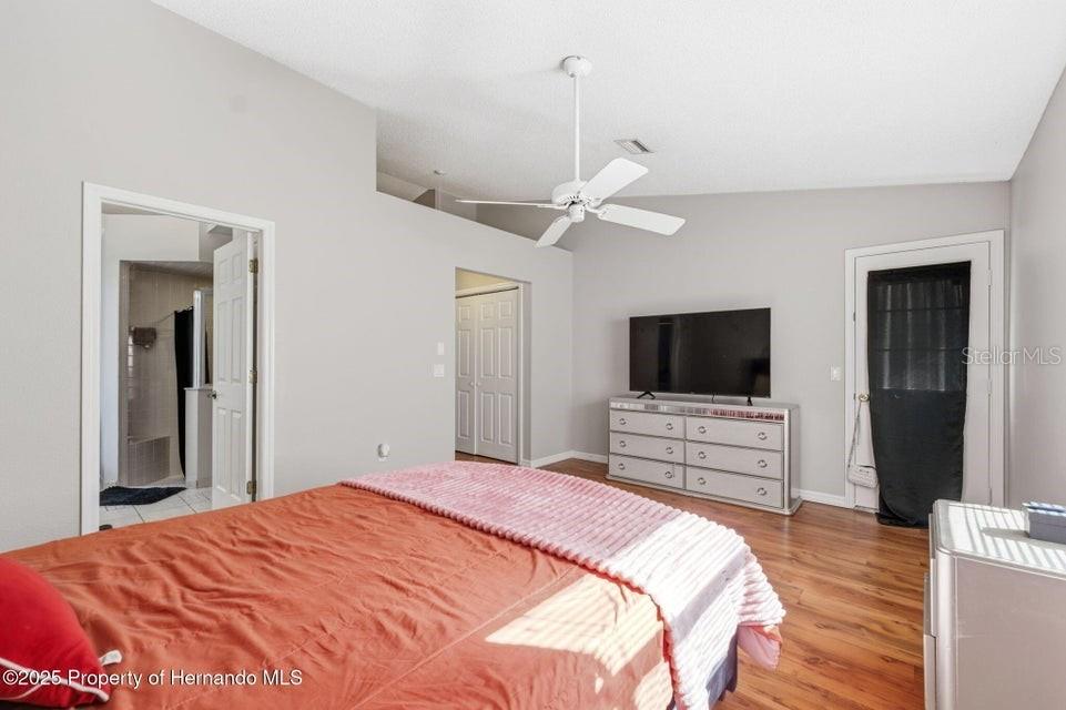 10290 Adler Street Spring Hill, FL 34608 - Photo 16 of 34 a bedroom with a bed and a flat screen tv
