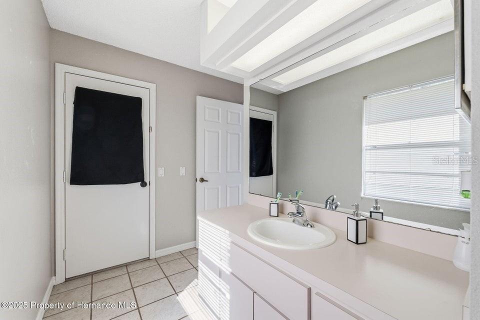 10290 Adler Street Spring Hill, FL 34608 - Photo 24 of 34 a bathroom with a sink and a mirror