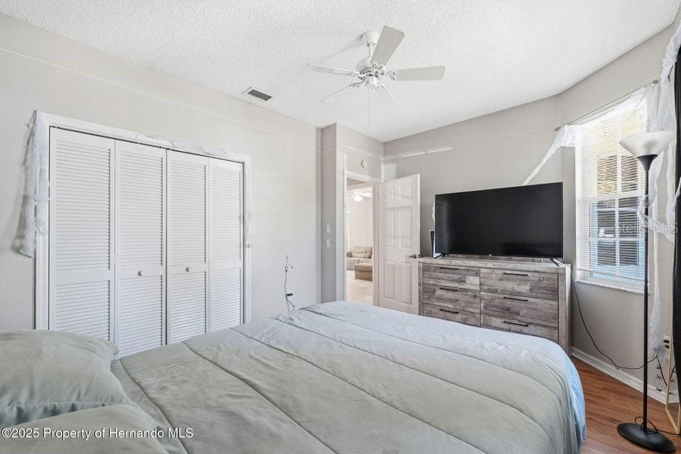 10290 Adler Street Spring Hill, FL 34608 - Photo 26 of 34 a bedroom with a bed and a flat screen tv