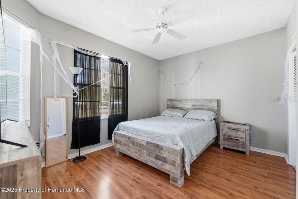 10290 Adler Street Spring Hill, FL 34608 - Photo 27 of 34 a bedroom with a bed and a table
