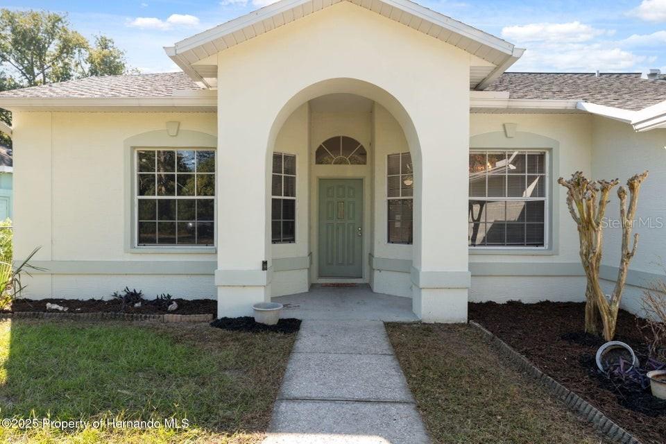 10290 Adler Street Spring Hill, FL 34608 - Photo 5 of 34 a front view of a house with garden