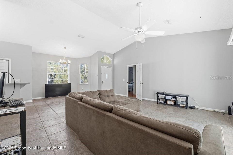 10290 Adler Street Spring Hill, FL 34608 - Photo 7 of 34 a living room with furniture and a chandelier