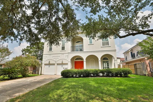 a view of a white house with a big yard and large tree