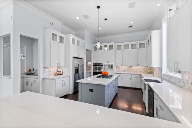 a kitchen that has a lot of cabinets a sink and a refrigerator