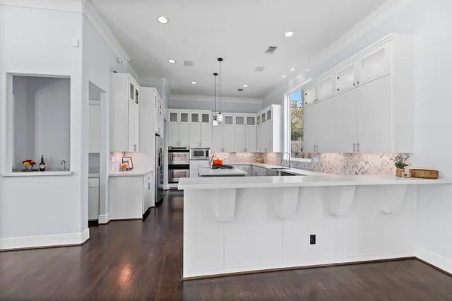 a kitchen with stainless steel appliances a sink a stove a refrigerator and cabinets