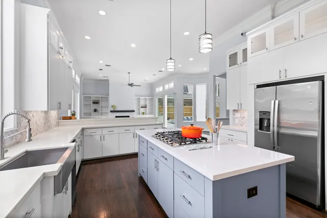 a open kitchen with stainless steel appliances kitchen island a sink stove and refrigerator