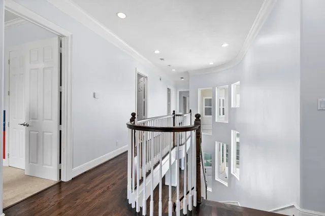 a view of a hallway with wooden floor and staircase