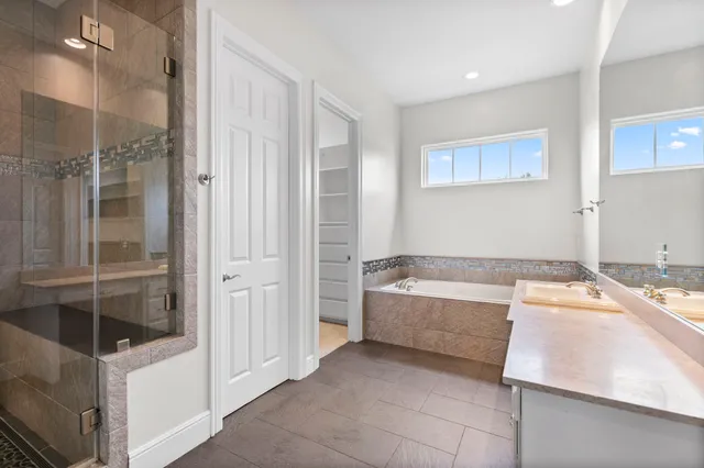 a bathroom with a tub shower and sink