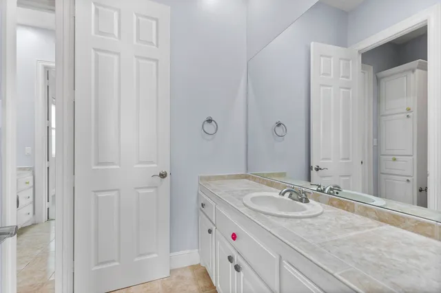 a bathroom with a granite countertop sink and a mirror