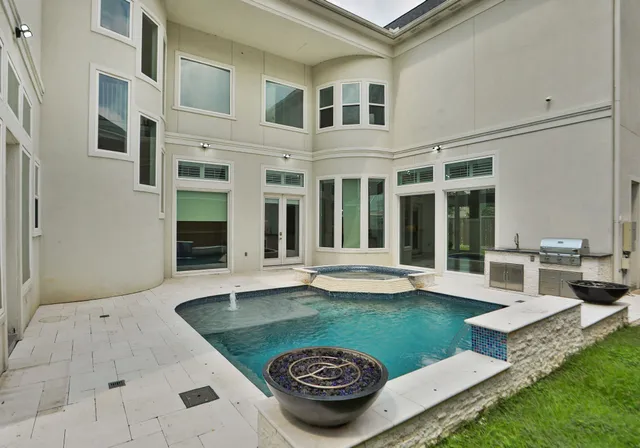 a view of a house with backyard sitting area and swimming pool