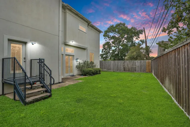 a view of a backyard with wooden fence and a bench