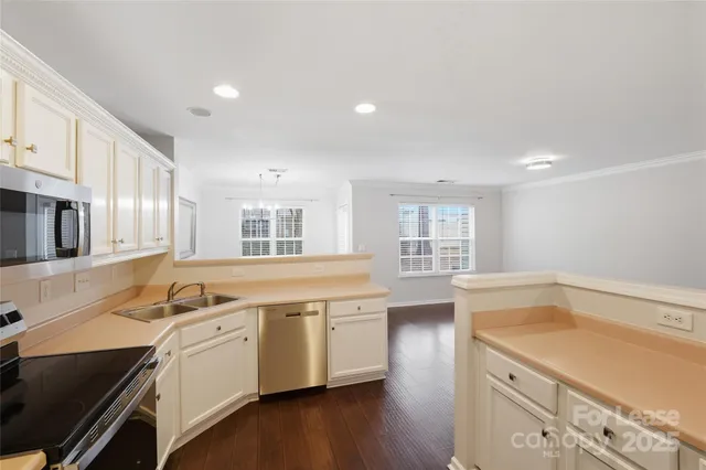 a kitchen that has a sink a stove and cabinets