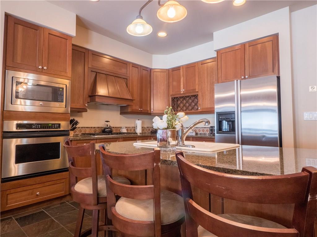 280 Trailhead Drive, Unit 3020 Keystone, CO 80435 - Photo 17 of 24 a kitchen with kitchen island granite countertop a stove refrigerator and cabinets
