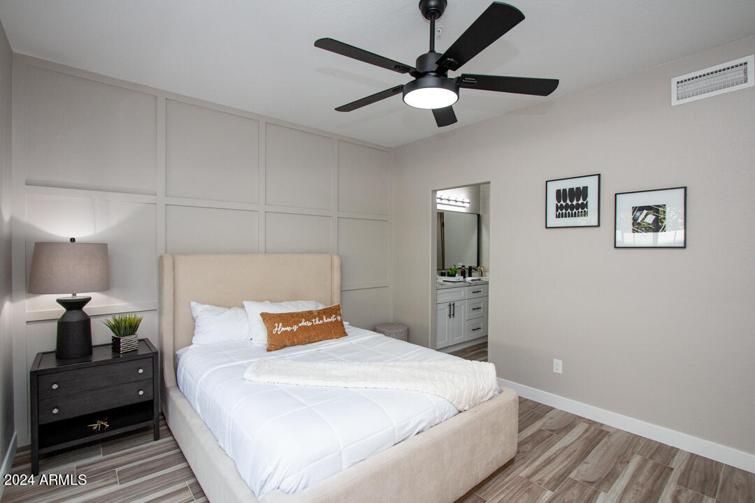 7710 East Gainey Ranch Road, Unit 137 Scottsdale, AZ 85258 - Photo 23 of 56 a bedroom with a bed and a chandelier