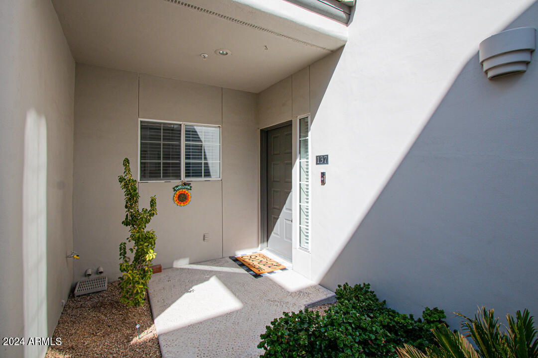 7710 East Gainey Ranch Road, Unit 137 Scottsdale, AZ 85258 - Photo 44 of 56 a hallway with potted plants and stairs