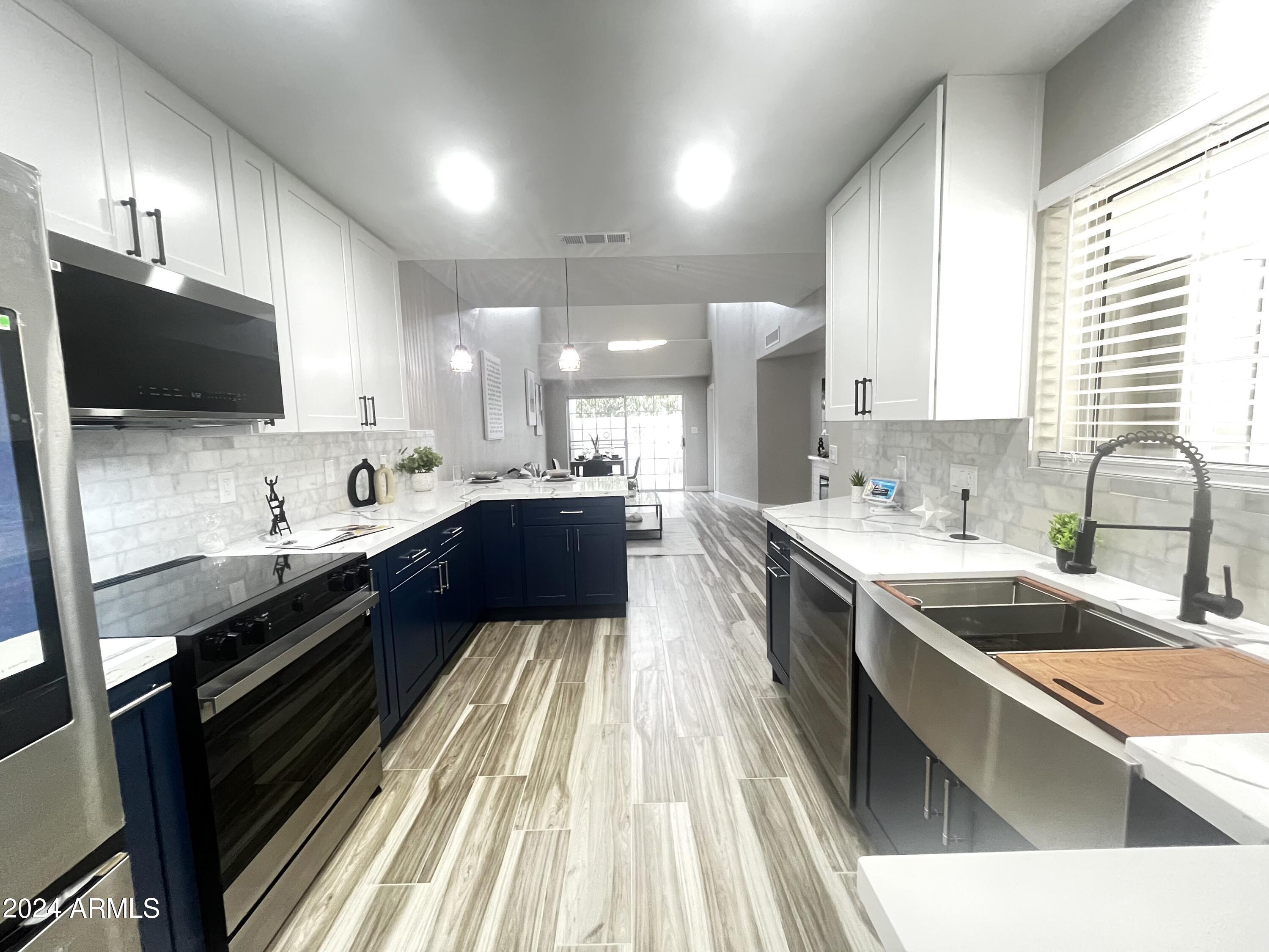 7710 East Gainey Ranch Road, Unit 137 Scottsdale, AZ 85258 - Photo 7 of 56 a large kitchen with a large counter top a sink a stove and cabinets