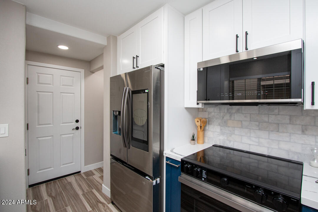 7710 East Gainey Ranch Road, Unit 137 Scottsdale, AZ 85258 - Photo 8 of 56 a kitchen with stainless steel appliances a refrigerator and a stove top oven