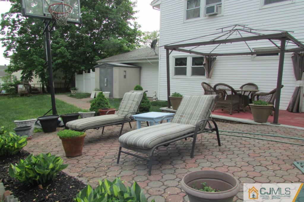 17 Gage Road East Brunswick, NJ 08816 - Photo 14 of 24 a view of a patio with couches table and chairs with wooden fence and plants
