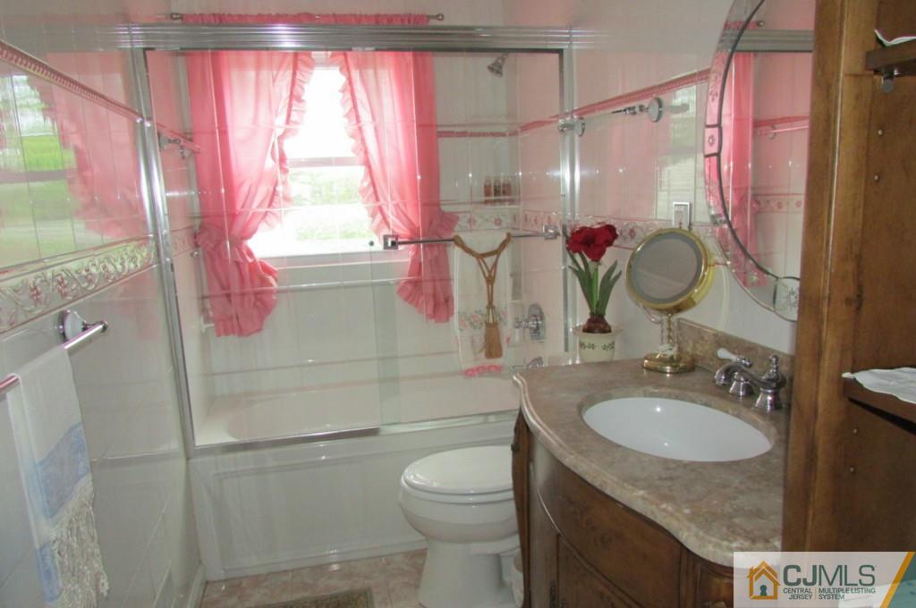 17 Gage Road East Brunswick, NJ 08816 - Photo 19 of 24 a bathroom with a granite countertop sink a toilet and shower curtain