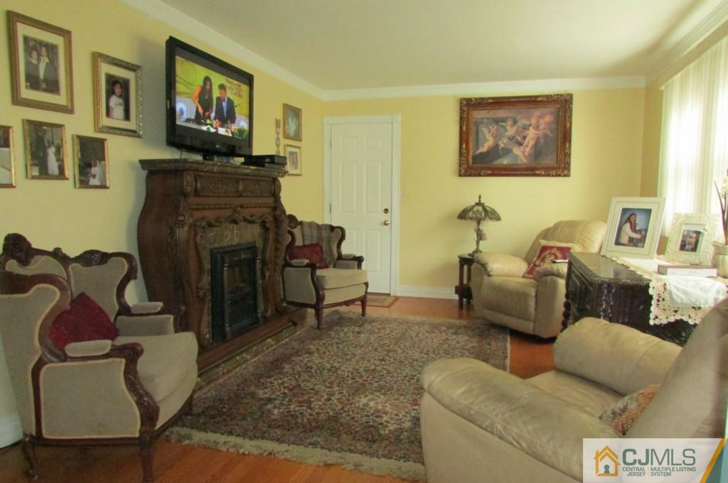 17 Gage Road East Brunswick, NJ 08816 - Photo 9 of 24 a living room with furniture a flat screen tv and a fireplace