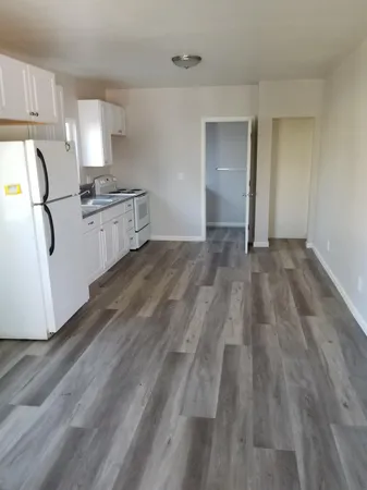 a view of empty room with wooden floor and cabinets