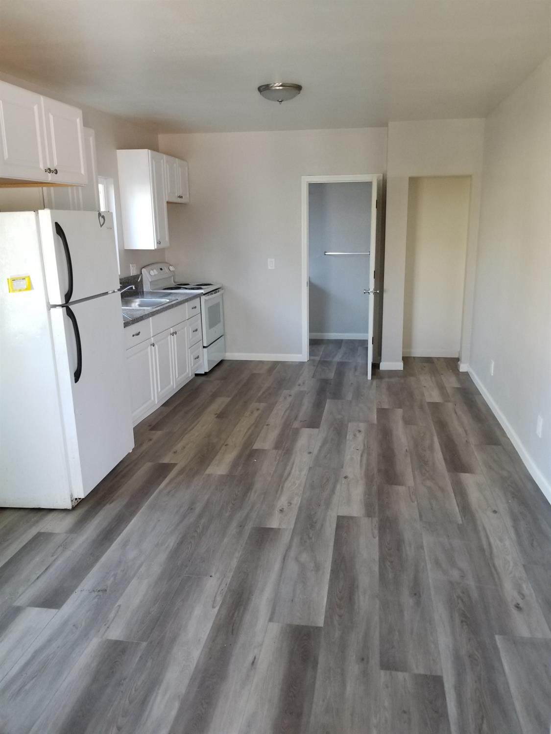 618 J Street Modesto, CA 95354 - Photo 3 of 38 a view of empty room with wooden floor and cabinets