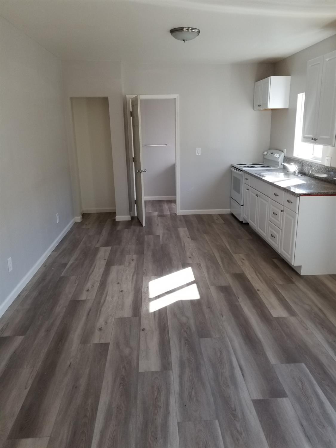 618 J Street Modesto, CA 95354 - Photo 6 of 38 a view of kitchen and empty room with wooden floor