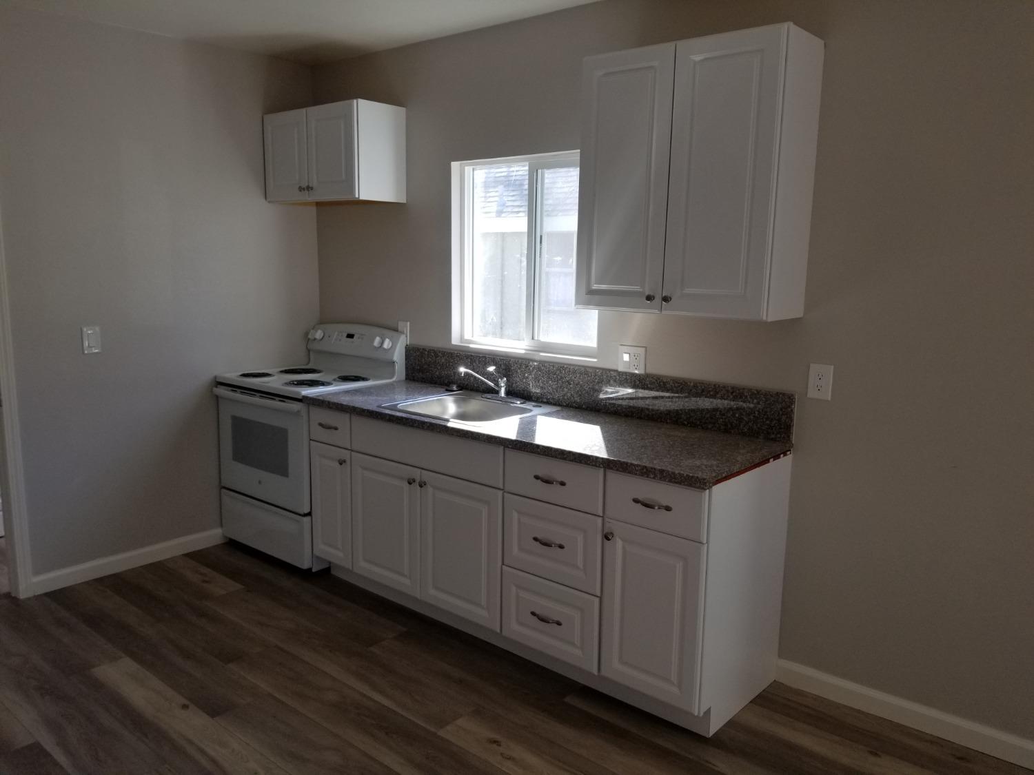 618 J Street Modesto, CA 95354 - Photo 7 of 38 a kitchen with stainless steel appliances granite countertop a sink a stove and cabinets