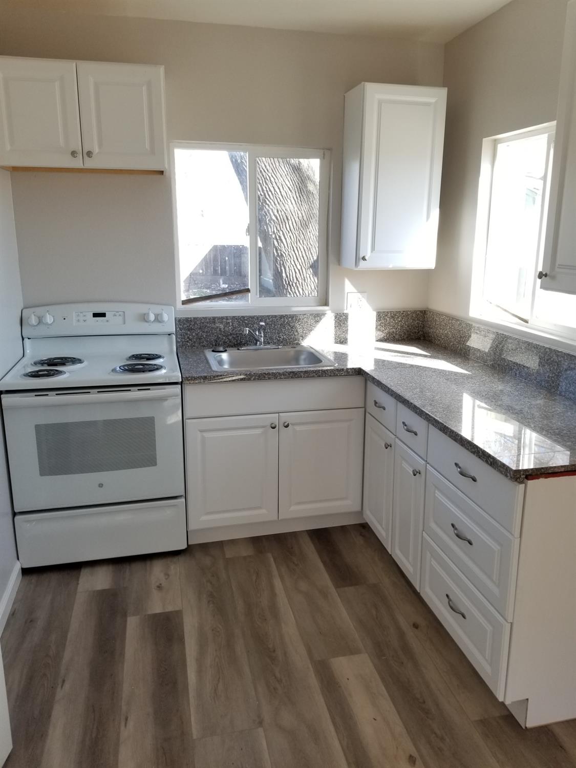618 J Street Modesto, CA 95354 - Photo 10 of 38 a kitchen with white cabinets stainless steel appliances and sink