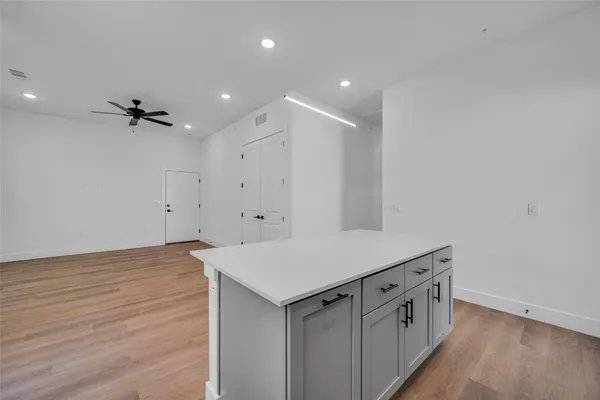 a view of an empty room with a ceiling fan and window