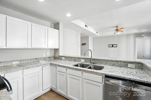 a kitchen with granite countertop white cabinets and a sink
