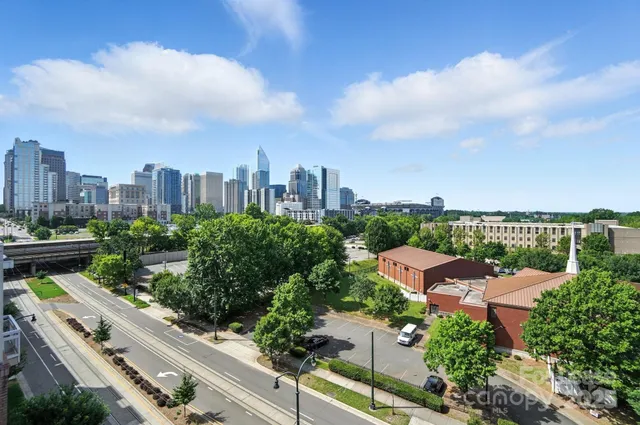 an aerial view of a city with lots of residential buildings ocean and mountain view in back