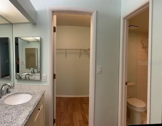 a bathroom with a granite countertop sink toilet and shower