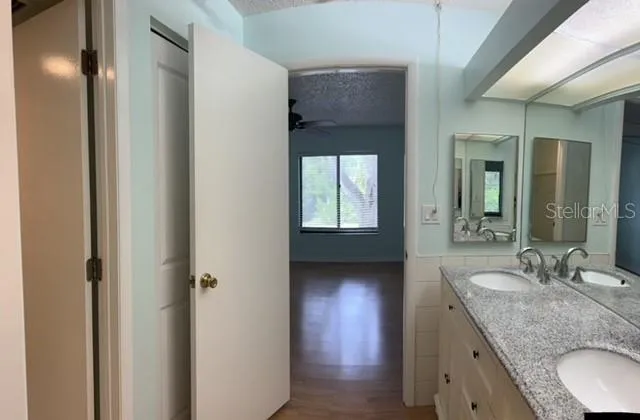 a bathroom with a granite countertop sink and a mirror